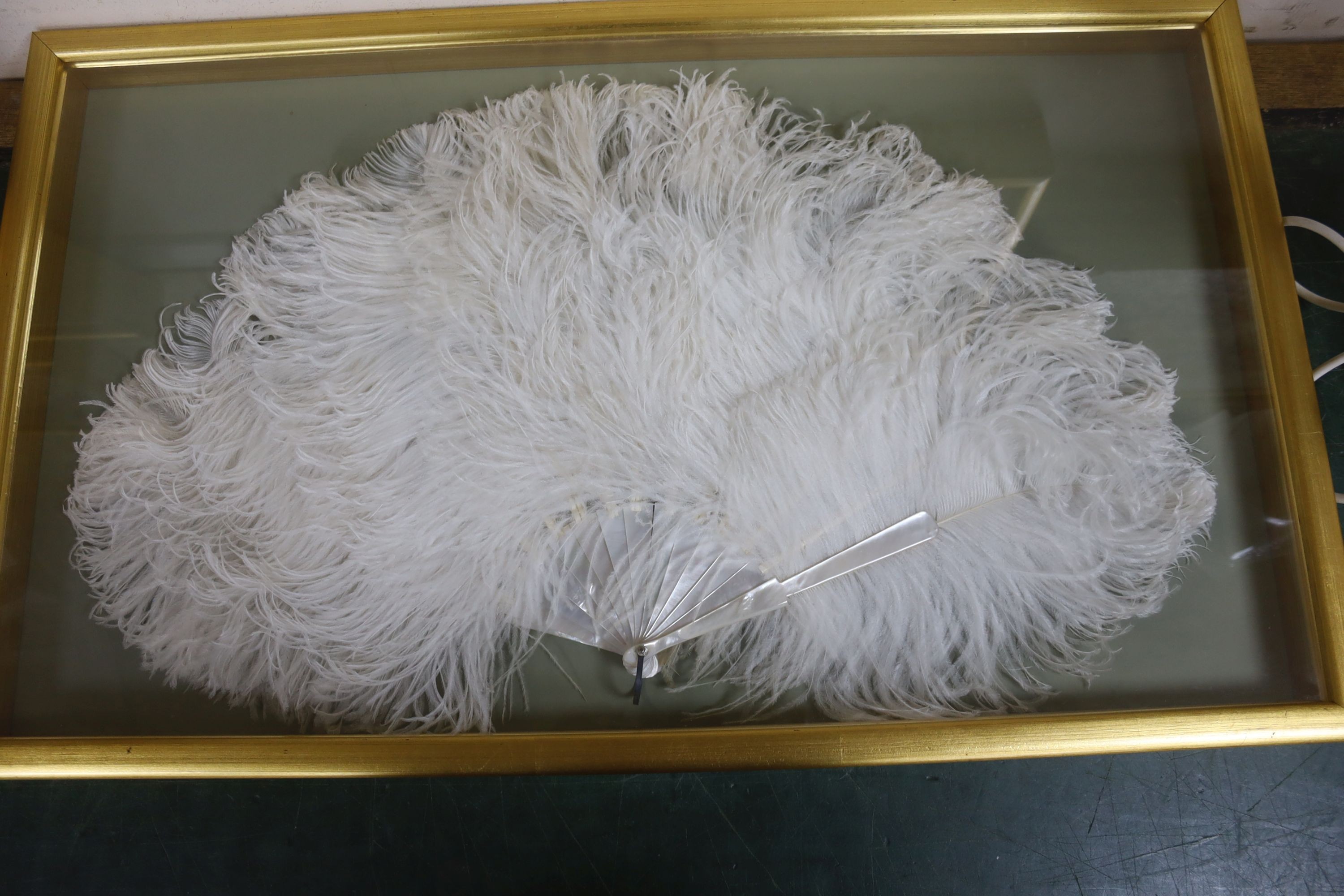 An ostrich feather fan, case 45 x 75.5 cm and a pair of cased 19th century bead worked face screens